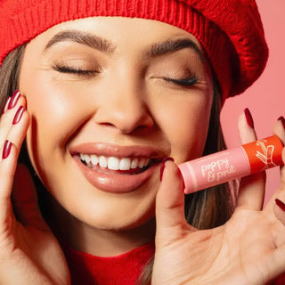 Woman holding the Candy Cane Fluff holiday lip balm