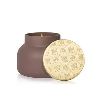 a taupe velvet-finish jar with a gold lid candle