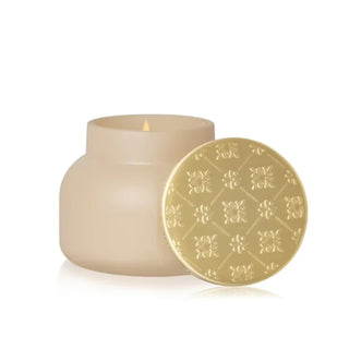 a cream velvet-finish jar with a gold lid candle