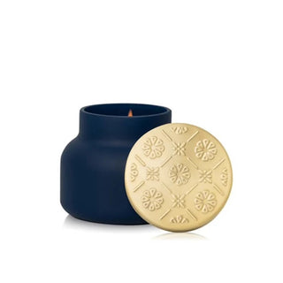 a navy velvet-finish jar with a gold lid candle