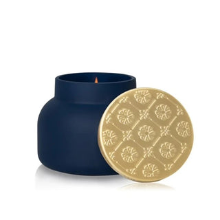 a navy velvet-finish jar with a gold lid candle