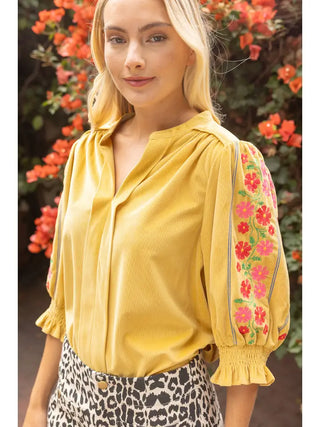The Millie Mustard Floral Corduroy Top – mustard yellow blouse with colorful floral embroidered sleeves, split neck, smocked cuffs